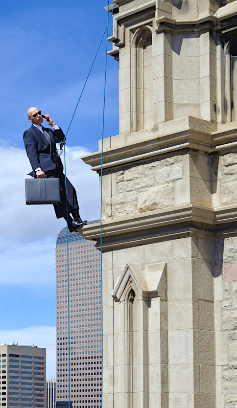 Business Man Talking on Phone Atop High Building