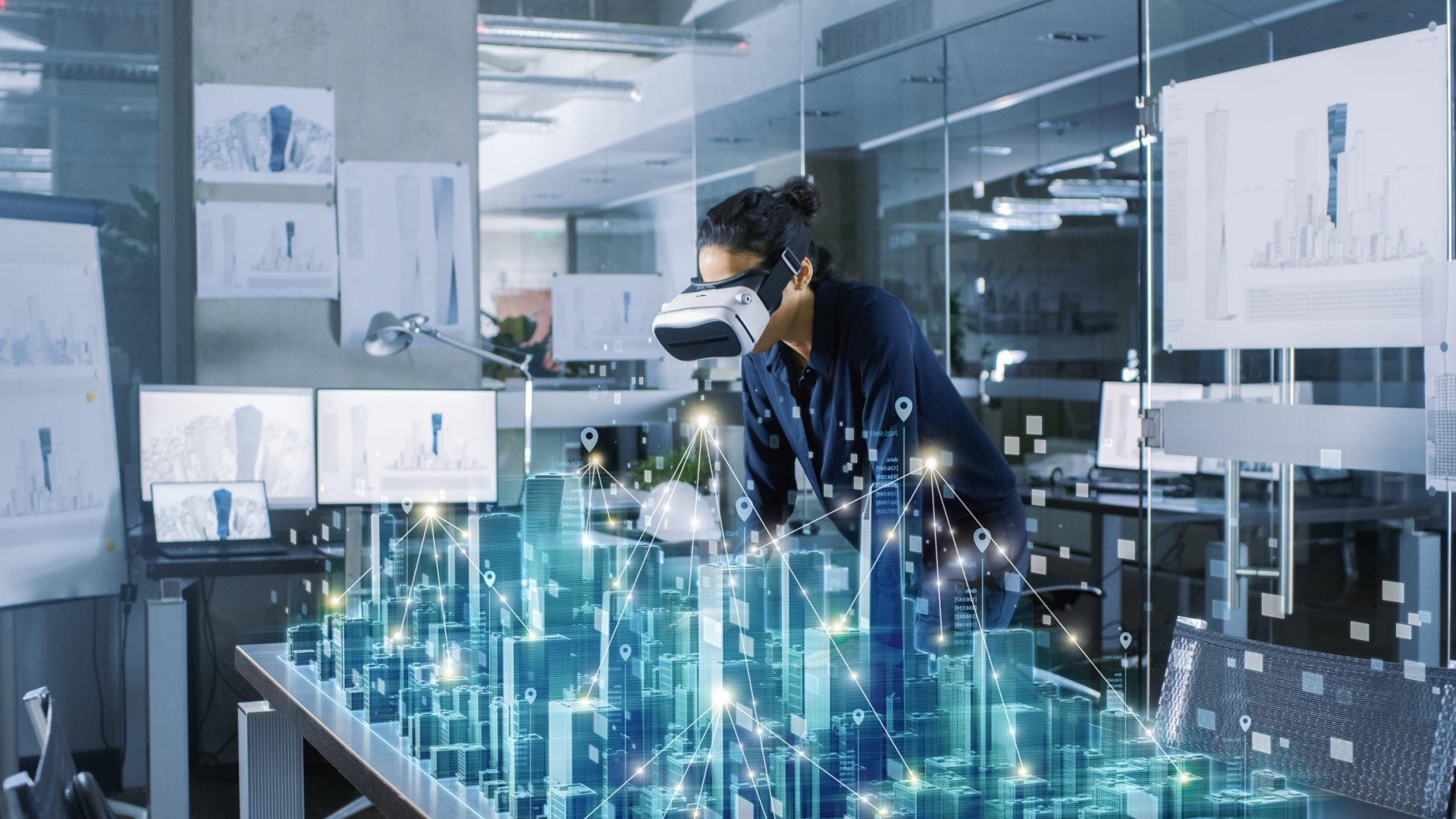 Futuristic design of office buildings. Woman using VR to look at 3D table
