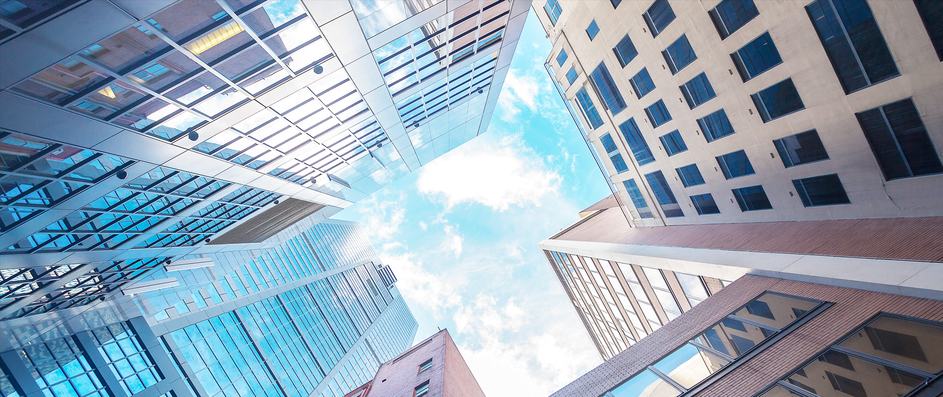 view from below of tall buildings in the center of a city