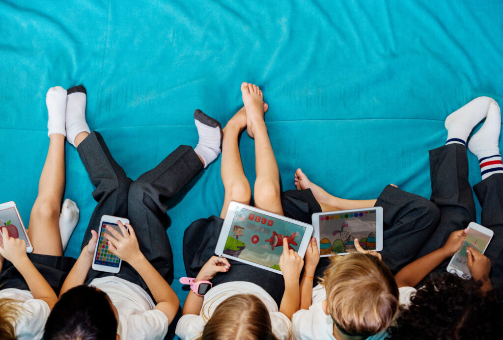 elementary school kids using phones and tablets