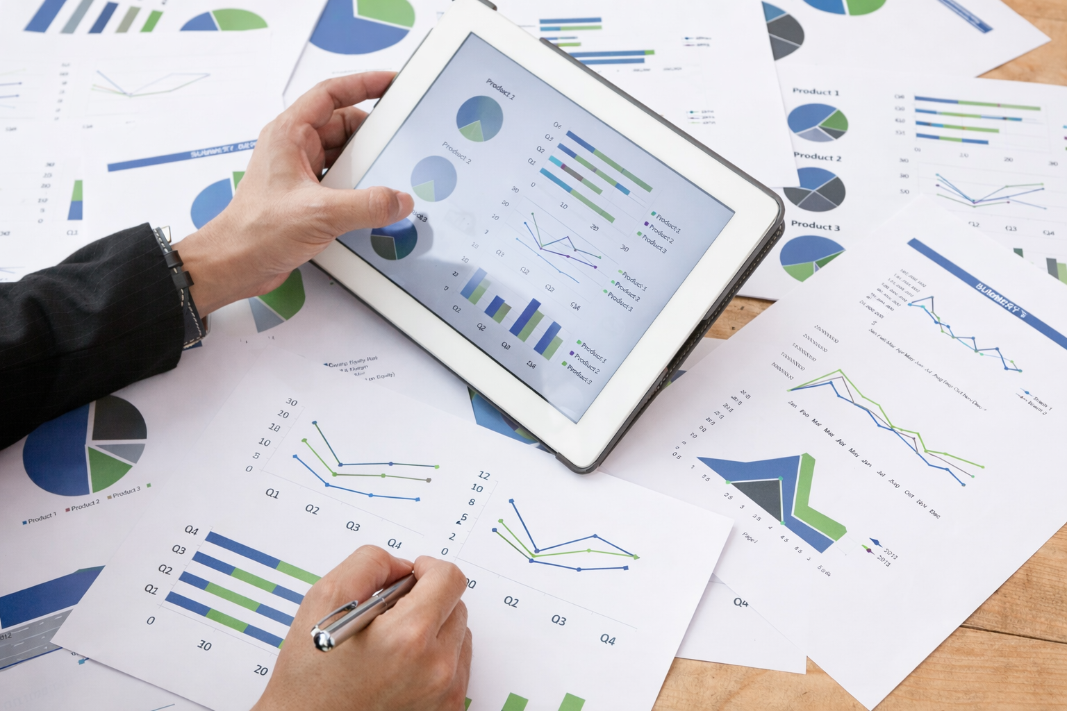Office worker reviewing business metrics on paper and online
